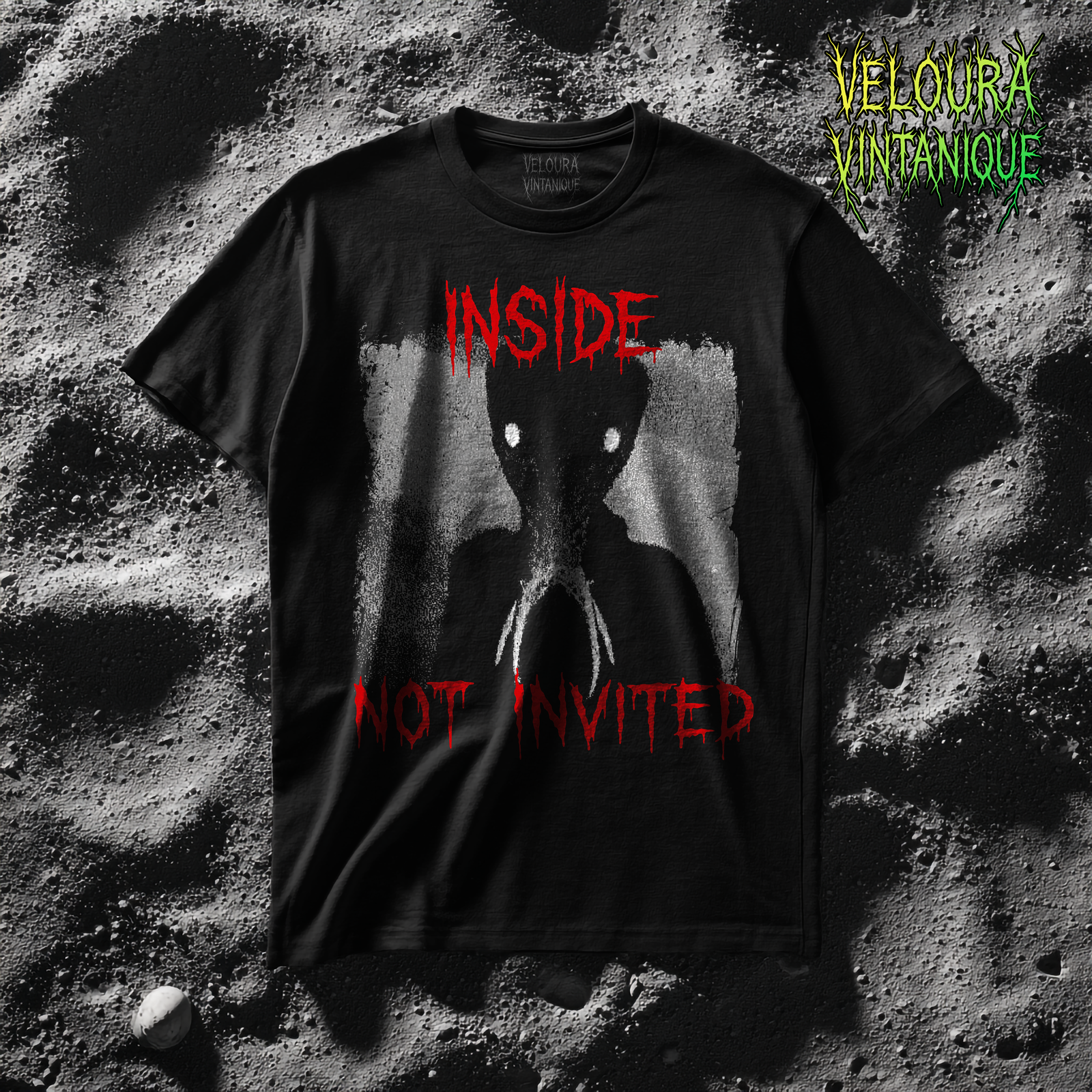 This black T-shirt features a disturbing analog horror inspired design with a grainy shadow-like humanoid figure in eerie shades of grey and white. The creature’s head is elongated and unnatural, its face more insect-like than human, with two glowing white eyes that stare directly out of the darkness. Claw-like mandibles extend from its face, making the figure appear even more unsettling. The background has a textured, static-like quality reminiscent of old VHS tapes or corrupted surveillance footage, amplifying the retro horror aesthetic. Above the creature, in bold dripping red letters, the word “INSIDE” is written, while below it the words “NOT INVITED” appear in the same sinister bleeding font. The combination of the faceless silhouette, piercing eyes, and ominous text creates an atmosphere of intrusion and dread, as if something has entered your home uninvited. This shirt embodies the analog horror style perfectly—ominous, cryptic, and deeply unsettling.