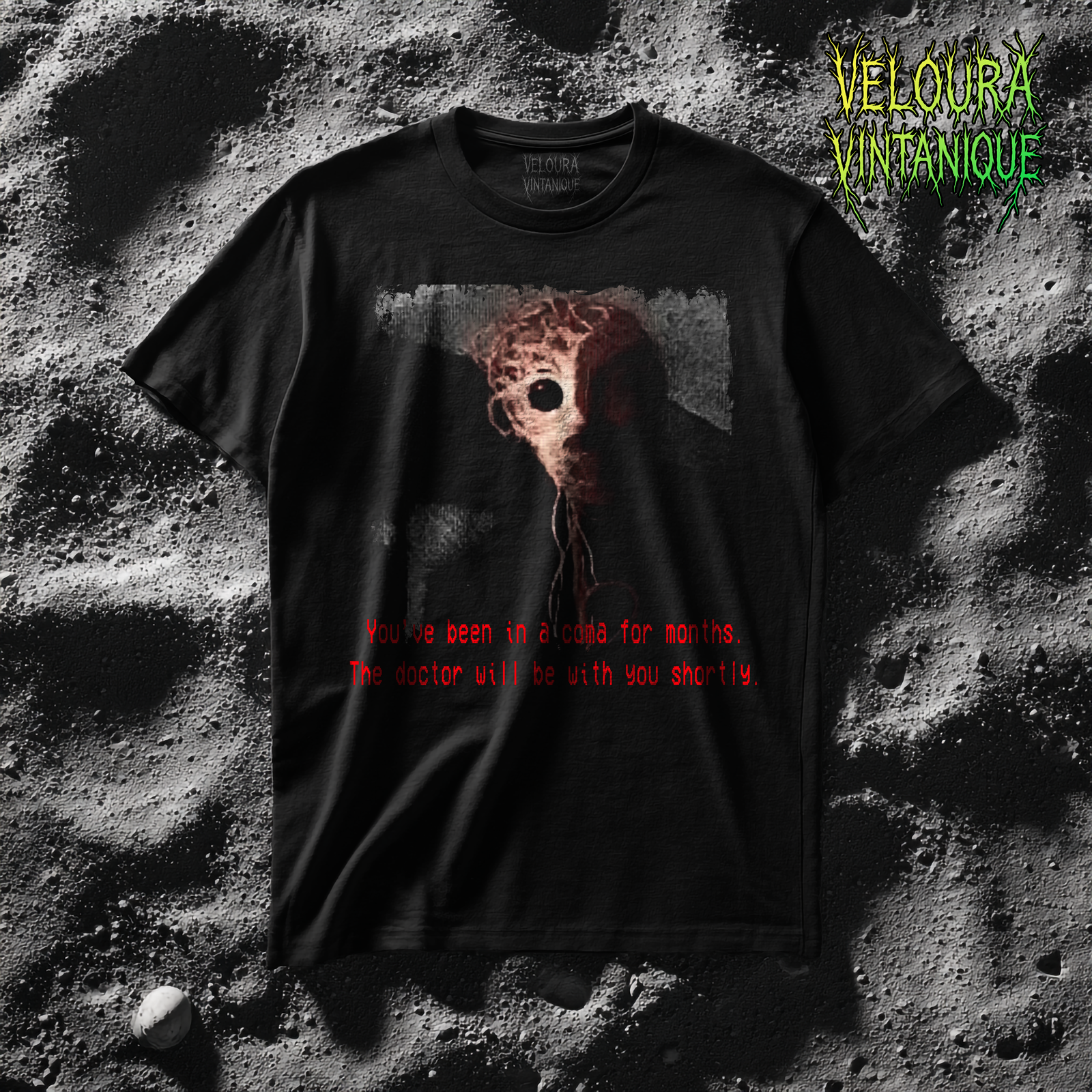 This T-shirt design features a disturbing analog horror–inspired image printed on a black fabric background. At the center is a grotesque humanoid figure, its head appearing as if it is made from tangled red sinew, nerves, and twisted strands of muscle. One large, dark, hollow eye socket and another bulging, almost reflective eye stare outward with an unsettling intensity. The creature’s face is partially consumed by shadow, giving it an incomplete and decayed appearance. Dangling tendrils extend downward from its head, resembling exposed nerves or loose organic wiring. The dark background amplifies the eerie atmosphere, making the figure appear as if it is emerging from void-like darkness. At the bottom of the shirt, in glitchy, blood-red text styled to mimic VHS subtitles, the phrase reads: “You’ve been in a coma for months. The doctor will be with you shortly.” The overall design combines medical horror, analog static aesthetics, and a surreal nightmare quality, making it look like a corrupted still frame from a lost hospital surveillance tap
