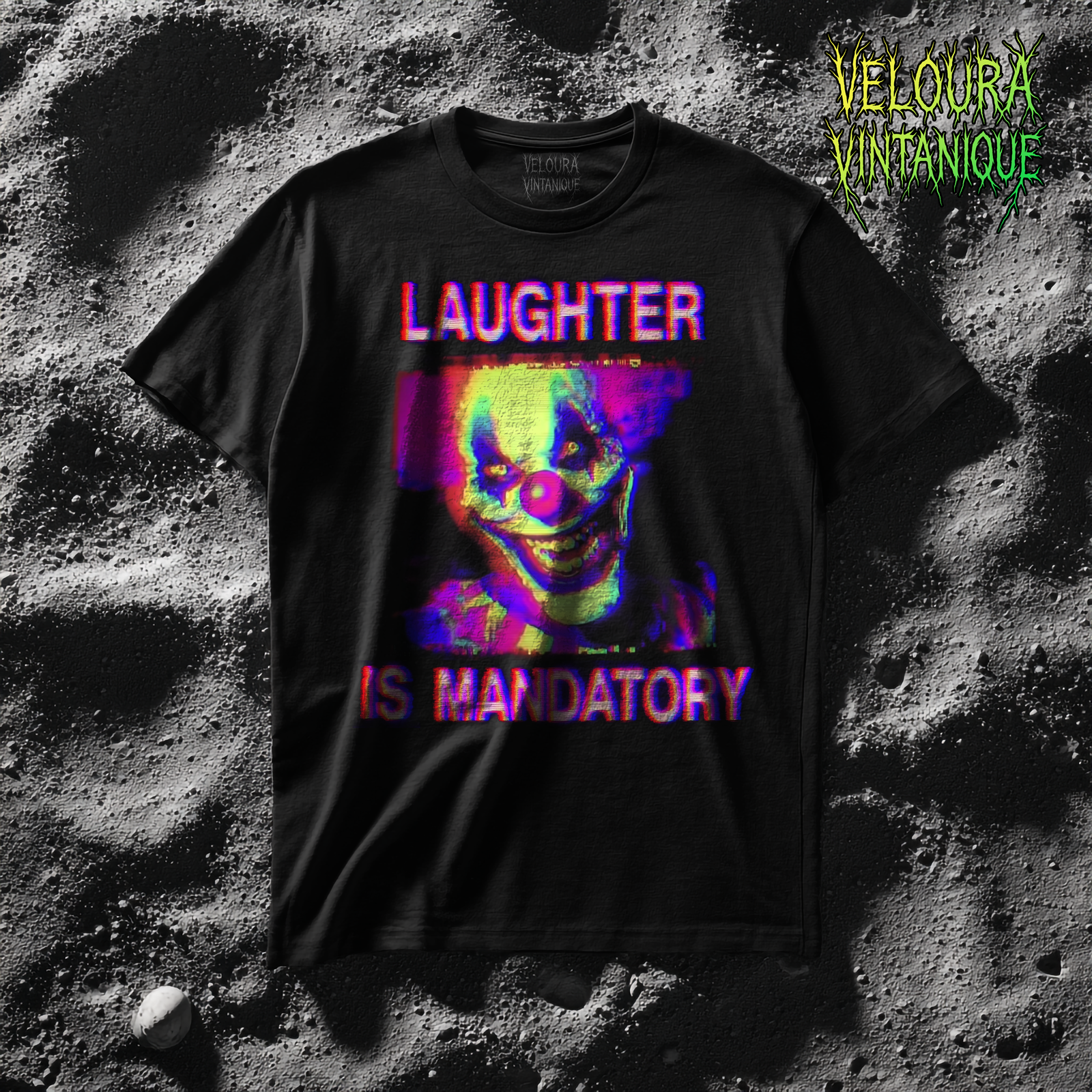 This t-shirt features a disturbing analog horror-inspired design with a brightly colored glitch effect. At the center is a menacing clown face with exaggerated features: glowing yellow eyes, a large red nose, and a wide, sinister grin full of sharp teeth. The entire image is distorted with heavy VHS static, neon glitch colors in red, blue, and purple, and chromatic aberration that gives the design a corrupted television screen effect. Above the clown, the bold distorted text reads “LAUGHTER”, and below, in the same glitchy style, “IS MANDATORY.” The black background and static overlay create an unsettling, cursed aesthetic reminiscent of creepy circus and analog horror broadcasts.