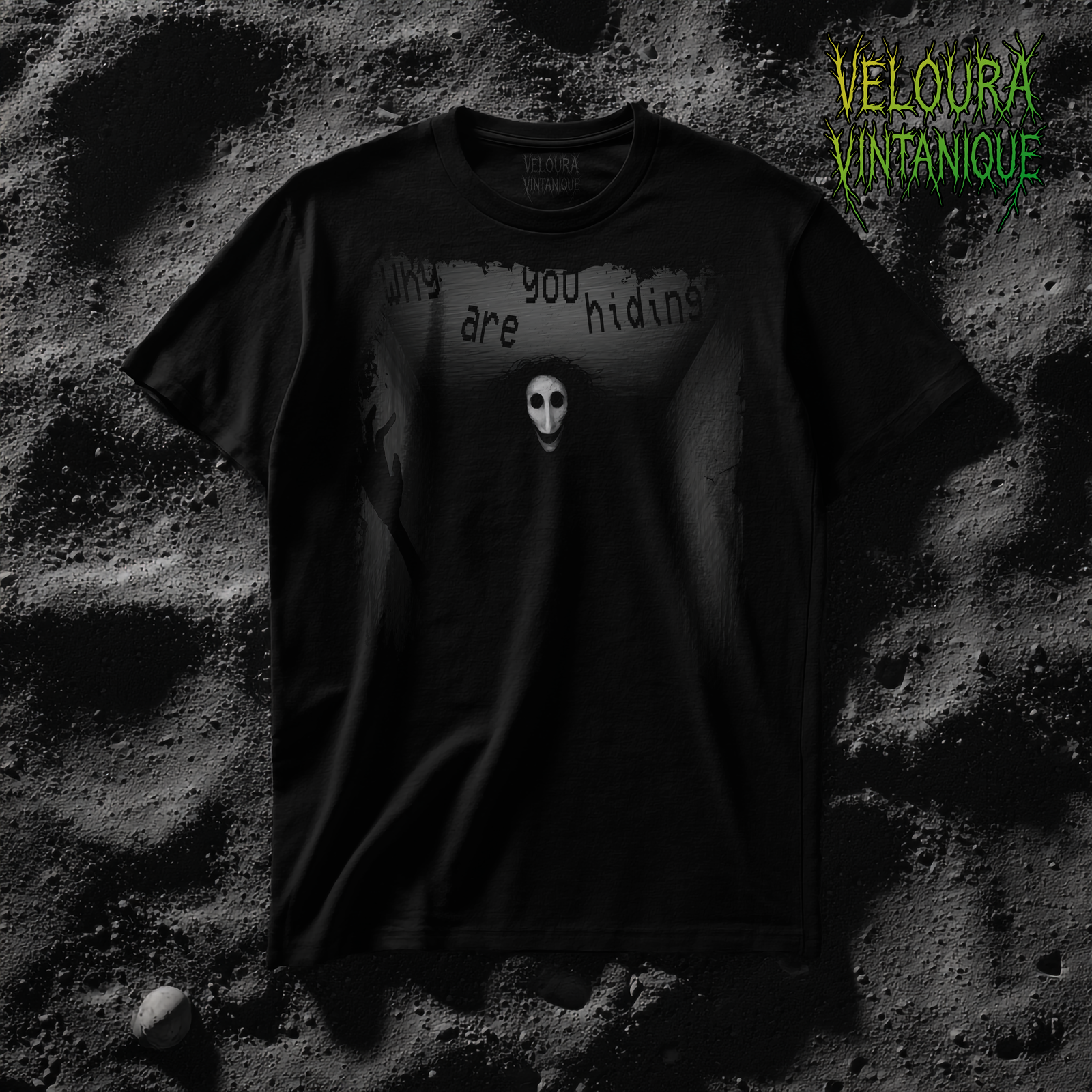 This T-shirt features a dark, horror-inspired design that shows a long, narrow hallway fading into blackness, with cracked and textured gray walls that create a claustrophobic atmosphere. At the end of the hallway stands a tall, shadowy figure with an unnaturally elongated body, its form blending almost completely into the darkness except for its pale, mask-like face with hollow black eyes and an eerie smile. Its messy, tangled black hair spreads around its head, enhancing the unsettling appearance. To the left side, a thin, skeletal hand emerges from the darkness, raised as if reaching out. Above the figure, distorted glitch-style text in irregular spacing and placement reads “Why are you hiding,” giving the design a sinister and taunting message. The entire artwork is rendered in grayscale tones, with the white mask face as the brightest and most eye-catching element, creating a disturbing focal point. The overall effect of the shirt is haunting, unsettling, and strongly influenced by analog horror aesthetics.