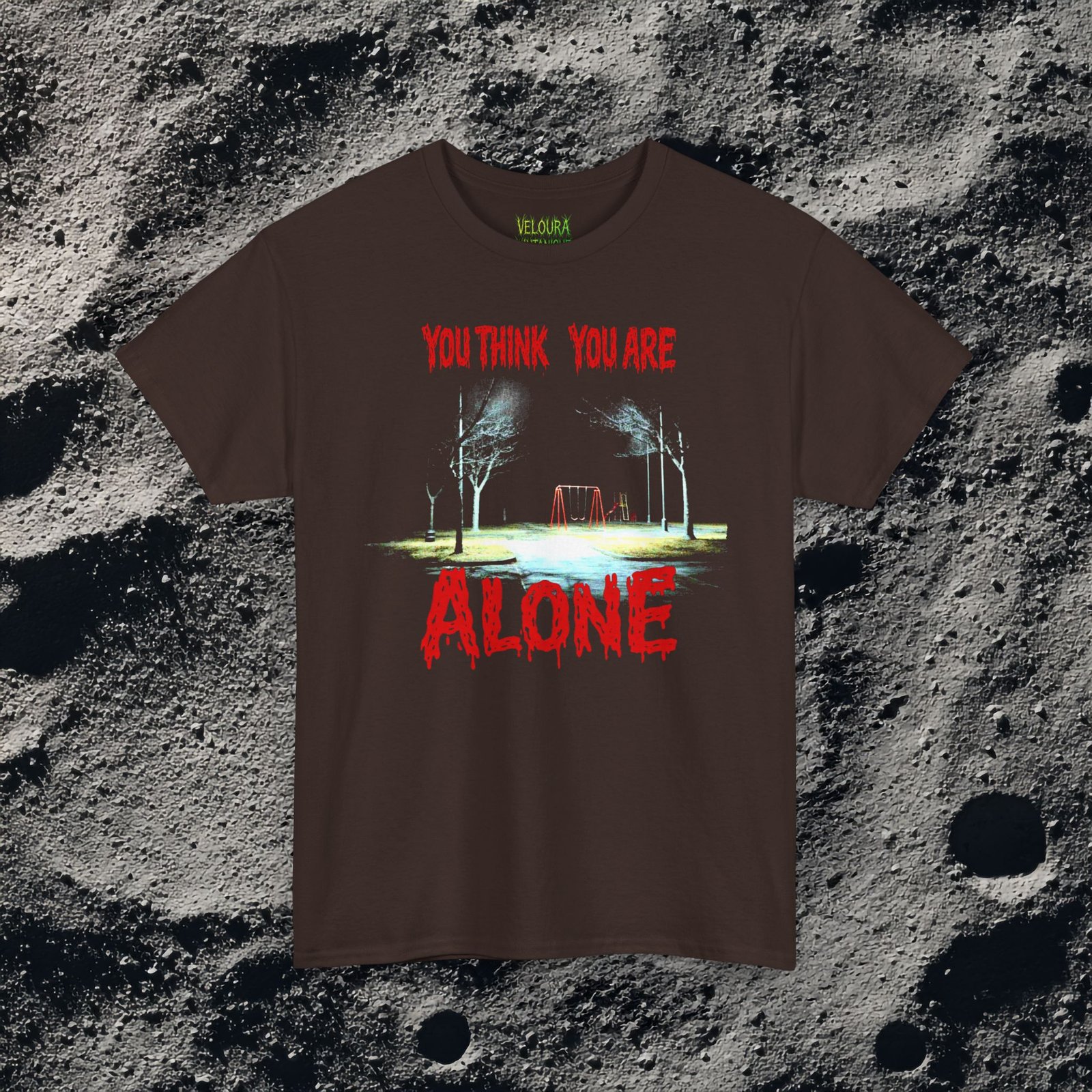 This unsettling double-sided design features a dark, rainy playground at night on the front with the text “You Think You Are Alone,” and a shadowy park path on the back with glowing eyes in the distance and the words “But the Corner of Your Eye Says Otherwise.” The grainy, low-light imagery and dripping red horror typography create a strong analog horror and liminal space atmosphere. Perfect for fans of creepy quotes, psychological horror, and eerie visual storytelling.