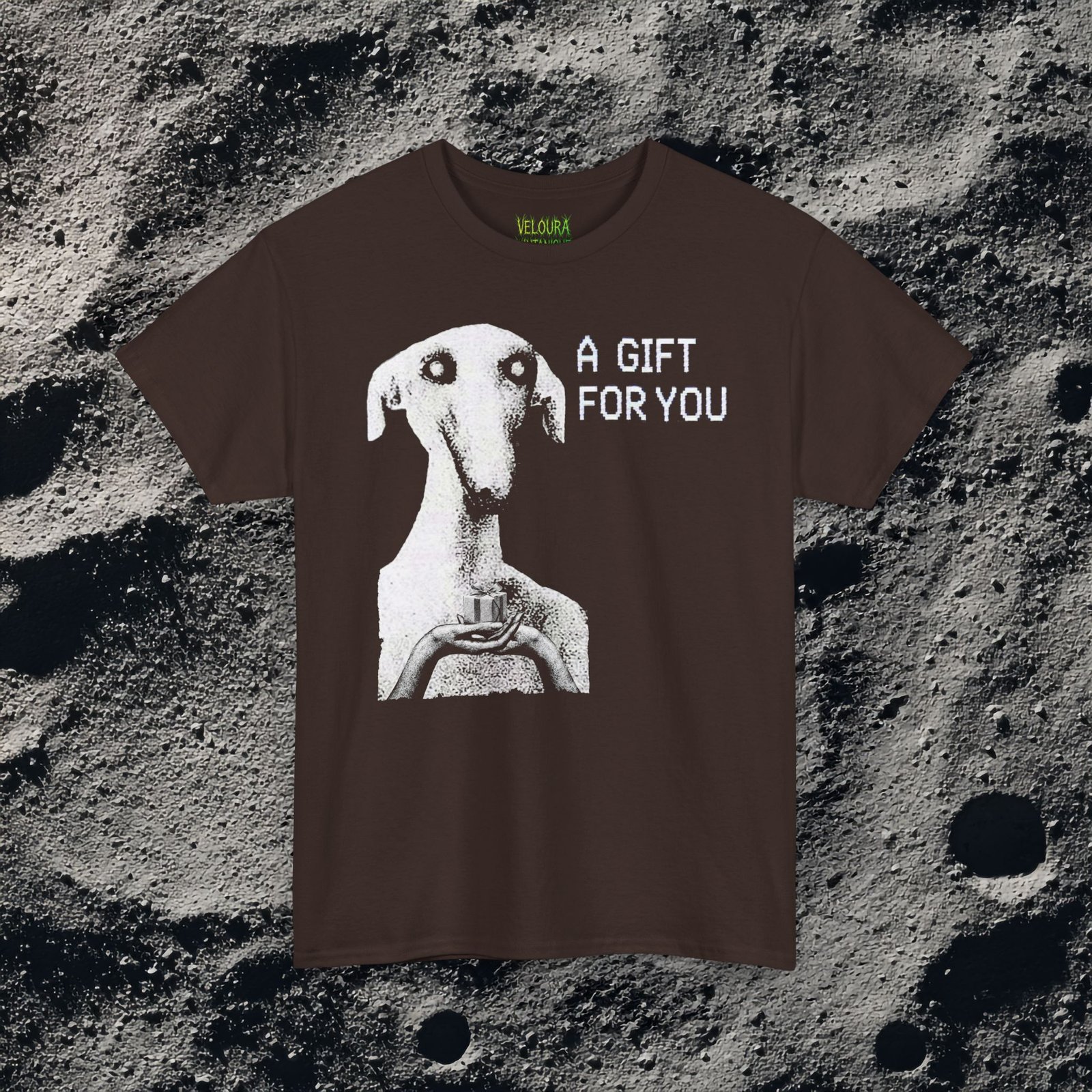 This unsettling horror T-shirt features a strange, eerie dog-like creature with hollow eyes and an unnatural expression, holding a small gift box in its hands. The grainy black-and-white texture creates a disturbing analog horror aesthetic reminiscent of cursed TV broadcasts and creepypasta imagery. The phrase “A GIFT FOR YOU” appears beside the figure in glitch-style typography, adding a mysterious and ominous tone. Perfect for fans of analog horror, creepy art, and dark streetwear.