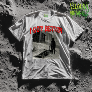 This unsettling horror T-shirt features a haunting black-and-white graveyard scene with a freshly dug grave and a shadowy figure standing beside it with glowing eyes. A small cross marks the grave while an eerie cabin sits in the background, creating a disturbing rural horror atmosphere. Above the scene, dripping red horror-style text reads “I GOT BETTER.” The gritty analog horror aesthetic gives the design a creepy found-footage vibe inspired by internet horror and dark humor.